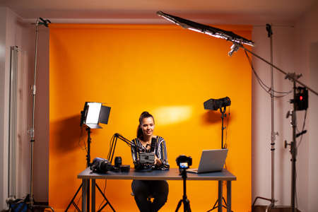 Videographer showing battery with v-mount in home studio for podcast. Professional videography gear...
