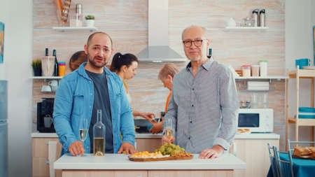 Extanded happy family having a video call in their new, modern, luxury kitchen Pov online internet...