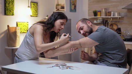 Drug addicted couple in the kitchen. Persons using to heroin, cocaine, amphetamine abuse with side...