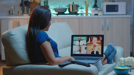 Woman freelancer having web chat conference sitting on sofa in living room. Remote worker discussing...