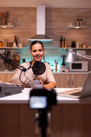 Vlogger on air during her online show using mixer and professional microphone. Online show production internet broadcast host streaming live content, recording digital social media communicationの写真素材