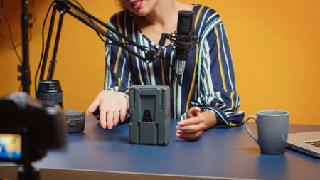 Close up of new media reviewer talking about v mount batteries in her new podcast episode....