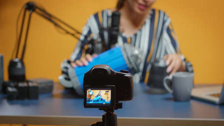 Close up of influencer recording on camera video light review. Social media star making online interent content about professional video equipment for web subscribers and distributionの写真素材