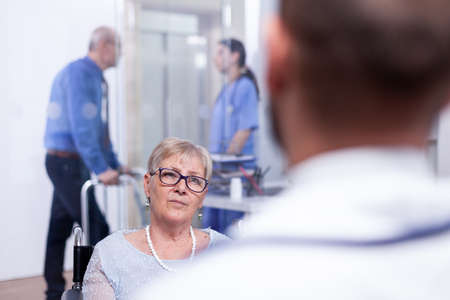 Handicapped woman in wheelchair at doctor appointment. Recovery treatment, help for disabled people....