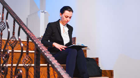 Overworked tired businesswoman reading financial raport of deadline project in the evening sitting...
