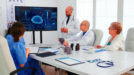 Doctor discussing about braing waves while is wearing headset with sensors. Monitor shows modern...
