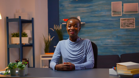Black business woman talking in front of camera having video call with partners. Pov of african freelancer working with remotely team discussing during online conference meeting using internet.の写真素材