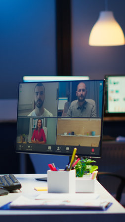 Businesswoman talking during video conference with team in midnight using pc in start up business office. Corporate meeting using technology network wireless discussing on webcam late at nightの写真素材