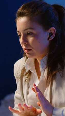 Employee having video conference working overtime from business office using laptop late night explining to remote colleagues strategic planning. Freelancer talking during virtual meeting at midnightの写真素材