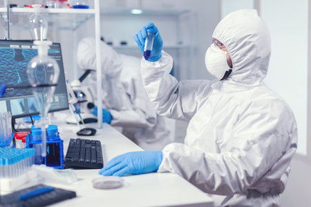 Doing research to find a vaccine for coronavirus dressed in ppe suit. Scientist in laboratory...