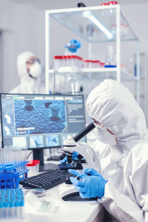 Team of microbiologists checking evolution on virus vaccine in moderl laboratory. Chemist researcher during global pandemic with checking sample in biochemistry labの写真素材