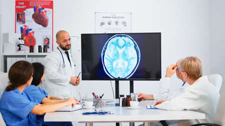 Team of doctors analysing digital x-ray and meeting together for sharing treatment ideas. Concept of brainstorming, meeting room, healthy and dashboard, analysing diagnosis of patientsの写真素材
