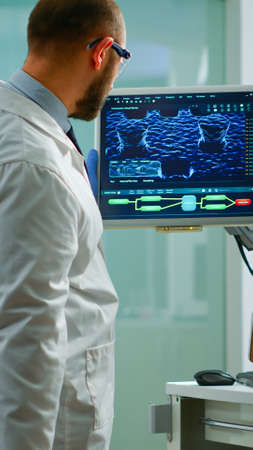Scientist worried about virus evolution analysing DNA scan image standing in equipped laboratory...