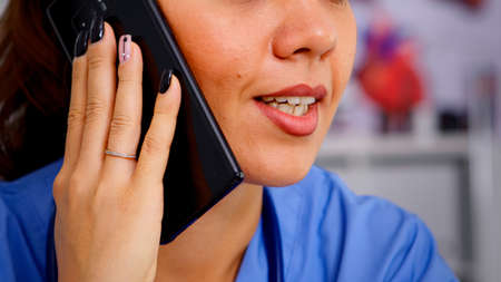 Healthcare physician consulting remote patients using phone in hospital wearing medicine uniform....