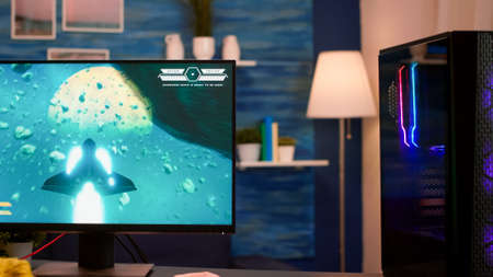 Videogamer using professional computer playing space shooter video game from home. Online streaming...