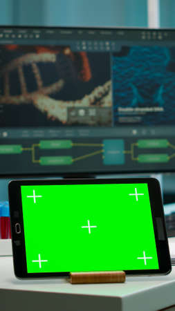 Display tablet with green screen, mock up on template placed on desk in scientific laboratory while...