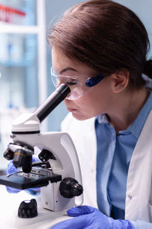 Medical scientist analyzing a test with microscope for pharmaceutical expertise. Modern laboratory...