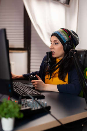 Side view of pro streamer with headphone playing shooter game competition using modern equipment....