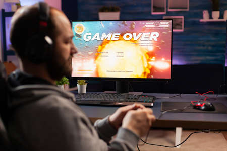 Disappointed esport gamer losing virtual tournament videogame using wireless controller. Defeated...