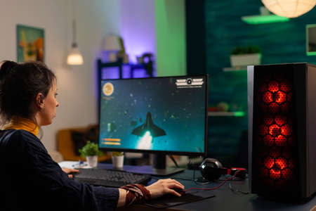 Professional gamer playing online space shooter videogames for digital gaming competition in home...