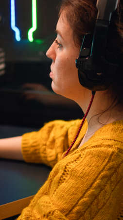 Pro gamer talking with teammates through headphones playing shooter video game having championaship....