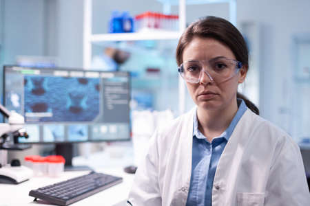 Portrait of woman scientist in chemistry laboratory looking at camera. Researcher in biology...