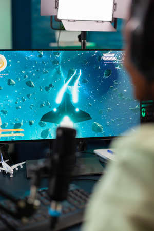 Back shot of esports streamer playing space shooter game during live tournament. Streaming viral...
