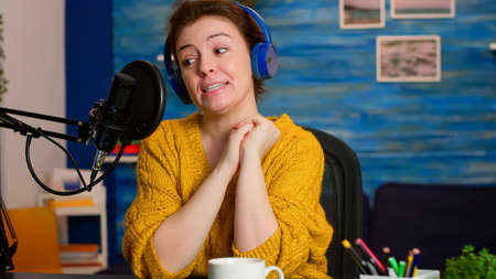 Influencer making online internet content for web subscribers in home podcast studio during livestreaming. On-air online production internet broadcast show host streaming live content for social mediaの写真素材