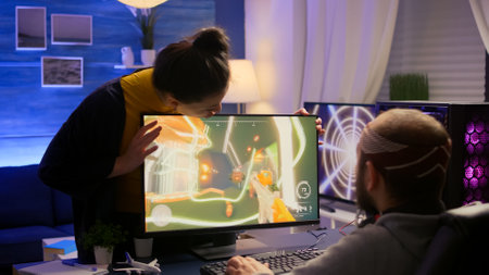 Cyber gamer fight with girlfriend about playing first person shooter video game for online competition. Pro player performing on powerful pc in gaming room home during online tournamentの写真素材