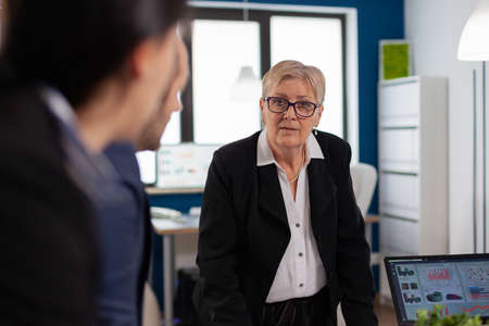 Group of diverse enthusiastic business people, marketing professionals, discussing project ideas. Multiethnic colleagues working planning success financial strategy discussing in office.の写真素材