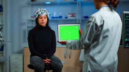 Neurologist doctor holding tablet with green screen in neurological research laboratory. Scientist...