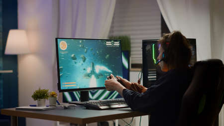 Back view shot of excited woman gamer streaming online video games and wining playing on RGB...