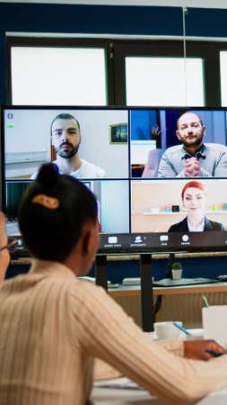 Emplyees workers having webcam group conference with coworkers speaking on video chat call with diverse colleagues online briefing. Diverse people talking at virtual meeting, online discussion.の写真素材