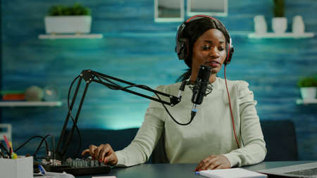 African influencer recording content using professional sound mixer and micophone in home studio....