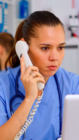 Medical practitioner answering phone calls and scheduling appointments in hospital. Healthcare...