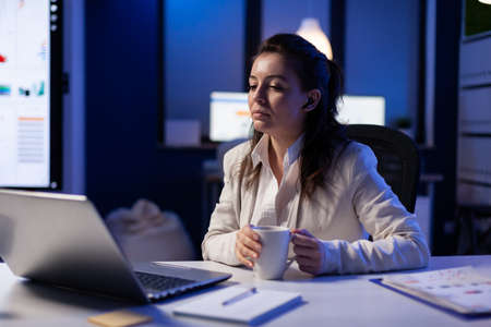 Workaholic businesswoman analysing economic statistics late at night in business office. Tired woman...