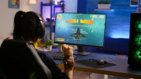 Player winning space shooter esport tournament wearing professional headset. Cyber performing on...