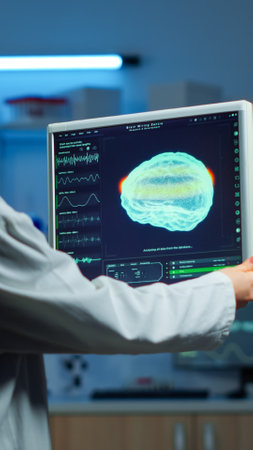 Neurologist doctor reading informations of patient looking at monitor analysing brain scan...