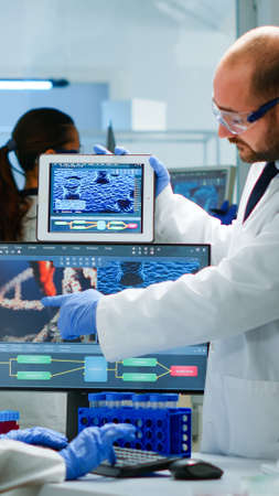Chemists worried about virus evolution comparing DNA informations from tablet discussing in...