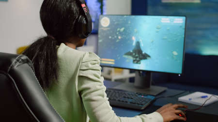 Excited african gamer with headphone winning important online esport competition of space shooter...
