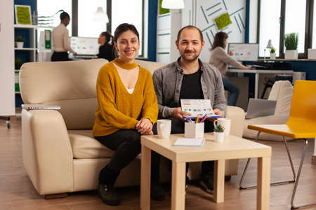 Start up company teamwork talking during video meeting sitting on couch listening and explaning to...