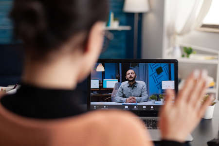 Student greeting her university teacher during virtual meeting using laptop computer. Caucasian...
