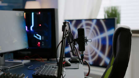 Game loading on display of RGB professional powerful computer and stream chat is prepared for virtual tournament. Streaming professsional microphone in empty gaming home studio with neon lights.の写真素材