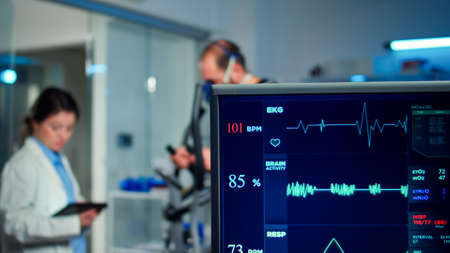 Specialist health supervisor increasing level of exercises measuring muscle endurance of athlete....