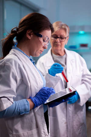 Team of scientist discussing blood analyzis using tablet pc, development. Specialist team of medical...