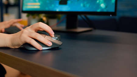 Close up hands shot of gamer pushing the keyboard buttons while playing online shooter video game. Virtual championship in cyberspace, esports player performing on pc during gaming tournamentの写真素材