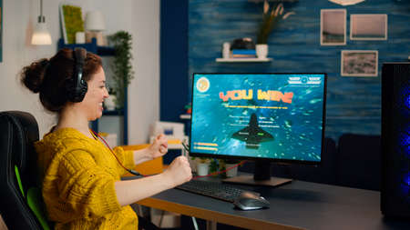 Joyful gamer celebrates victory winning shooter online video game on powerful personal computer....