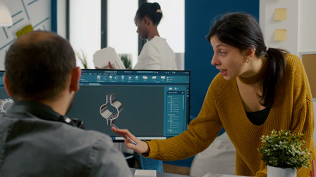 Industrial woman designer discussing with technician engineer working in CAD program, designing 3D...