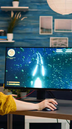 Professional gamer playing first-person shooter online video game on powerful personal computer with...