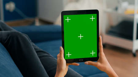 Close up of business woman hands holding tablet computer with mock up green screen chroma key...